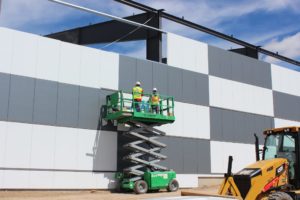 Workers put finishing touches on the checkered flag design of the raceway's exterior. The building will neighbor Bass Pro Shops in north Colorado Springs.